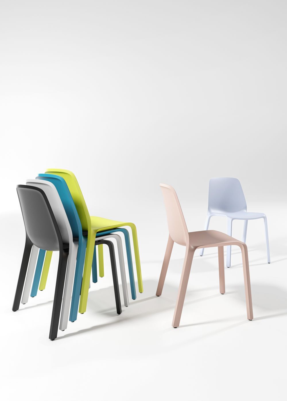Stapel von bunten ergonomischen Stühlen und ein einzelner rosa Stuhl auf weißem Hintergrund.