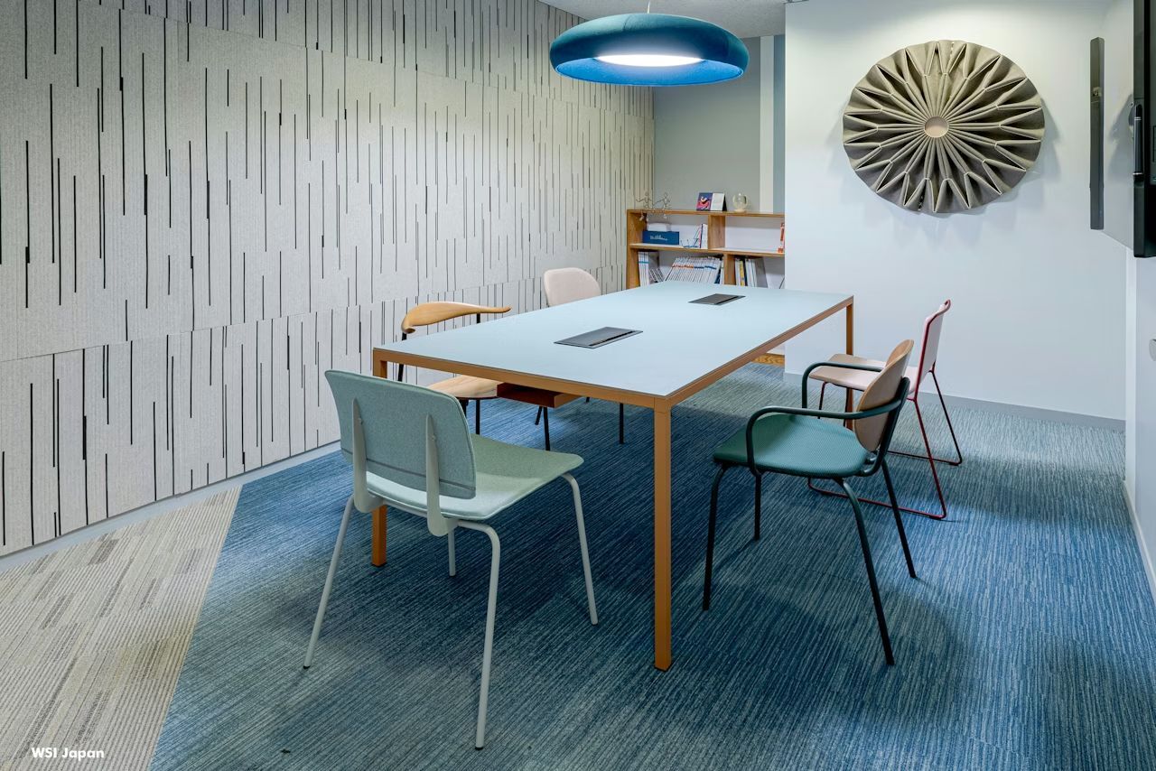 Moderner Besprechungsraum mit ergonomischen Stühlen, rechteckigem Tisch, stilvoller Wanddekoration und gemütlicher Beleuchtung.