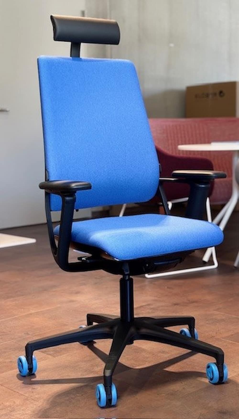 Ergonomischer Bürostuhl mit blauer Polsterung, Kopfstütze und Rollen, ideal für dynamisches Sitzen im Büro.
