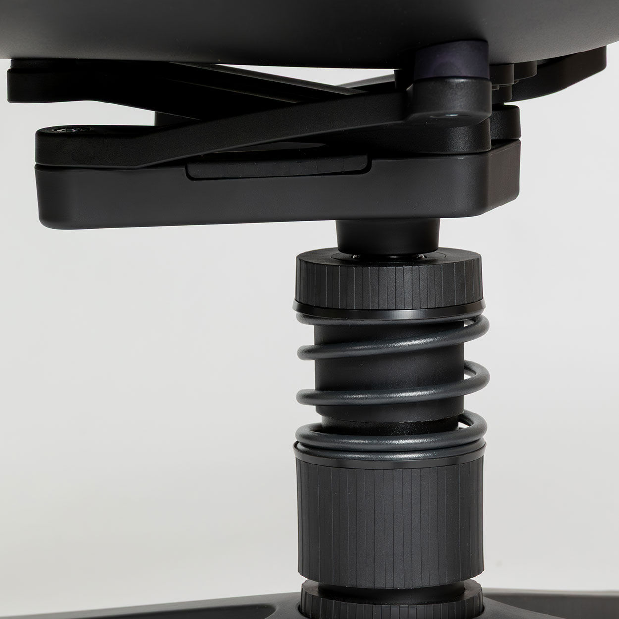 Nahaufnahme eines ergonomischen Stuhlmechanismus mit Spiralfederung für dynamisches Sitzen.