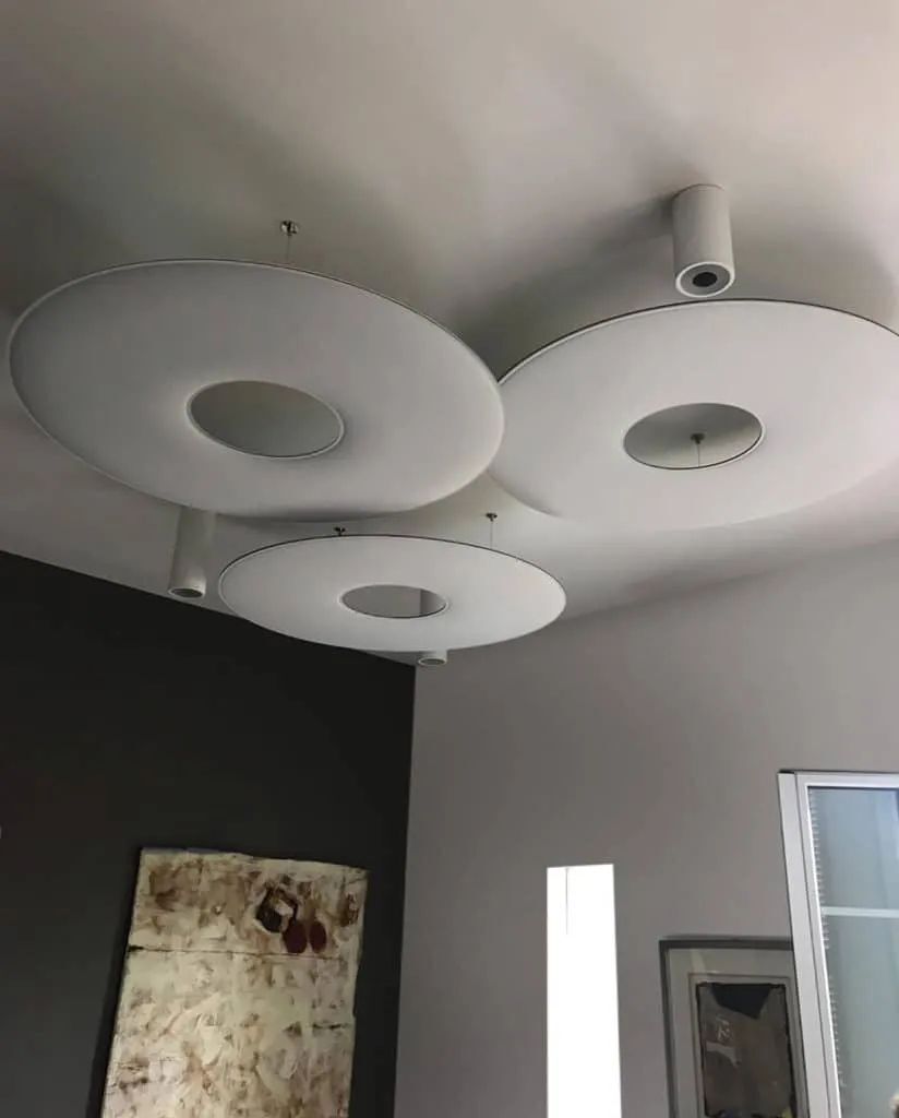 Moderne Deckenleuchten mit kreisförmigem Design in einem stilvollen, minimalistischen Innenraum.