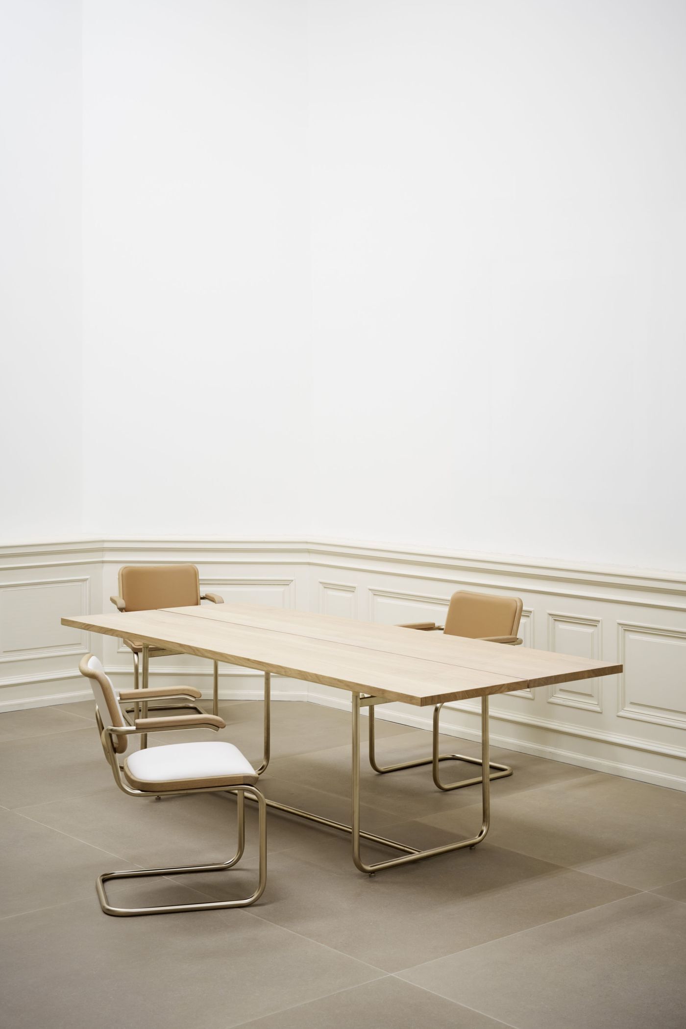 Moderner Konferenztisch mit vier ergonomischen Schwingstühlen in elegantem Raum mit hellen Wandverkleidungen.