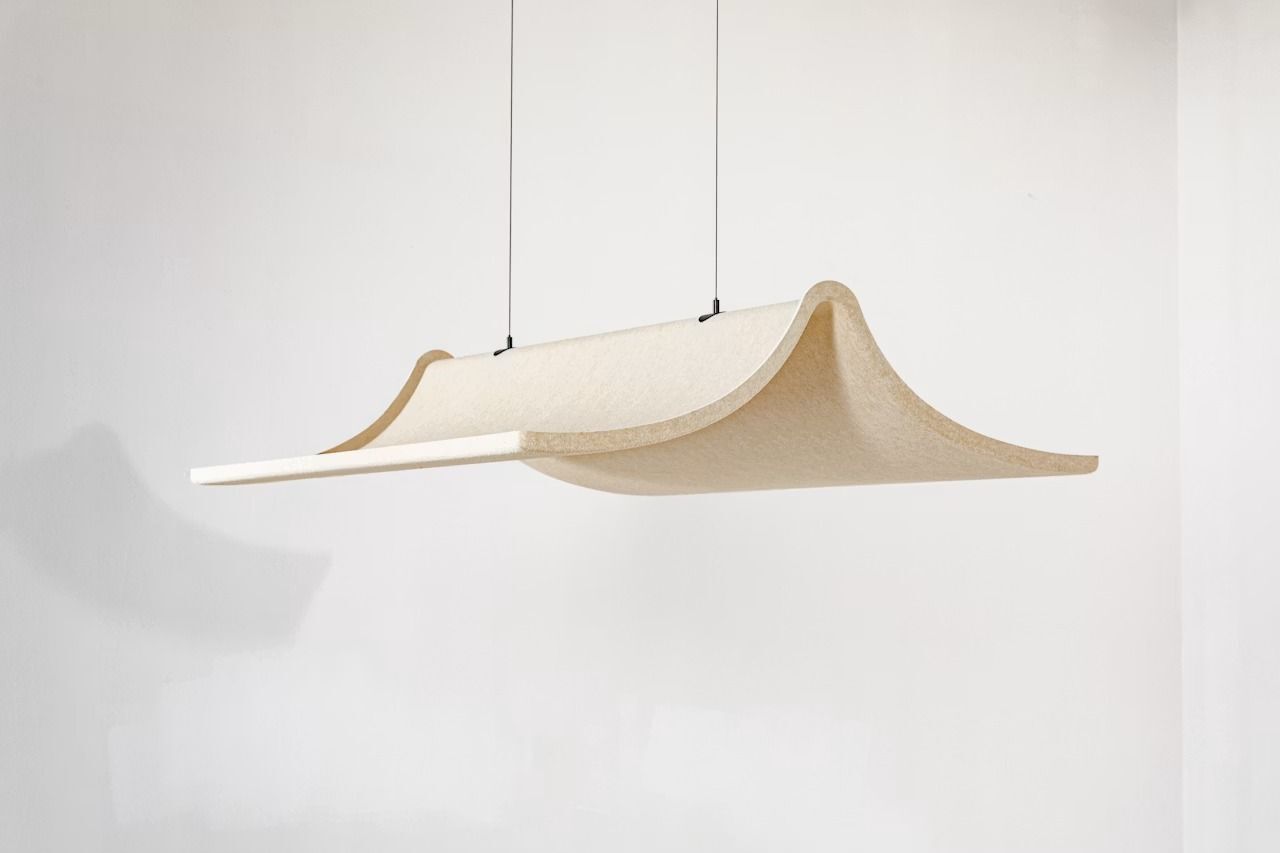 Moderne Hängelampe mit wellenförmigem, beige-grauem Schirm in minimalistischem Raumdesign, illuminiert von oben.