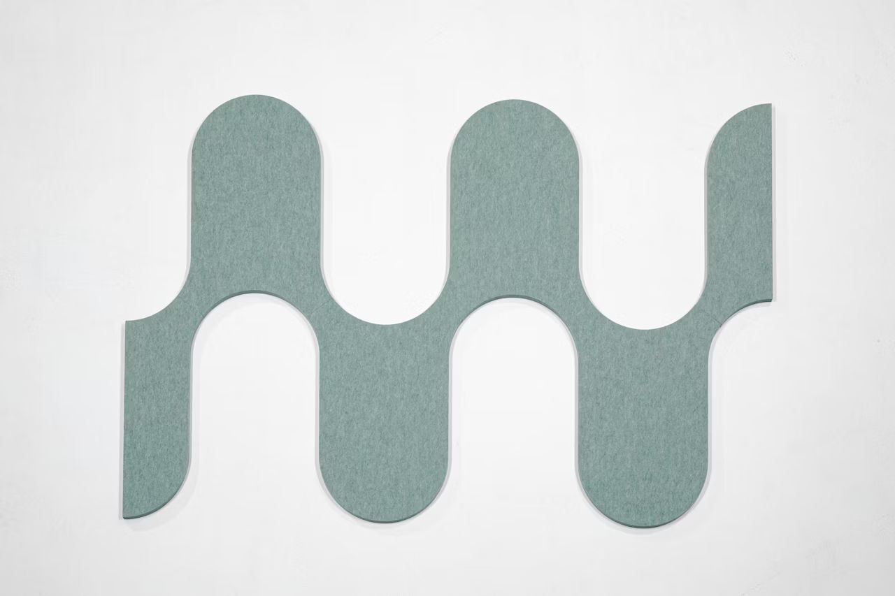 Wellige, graue Wandplatte in stilisiertem Design, ideal für moderne Büroumgebungen.