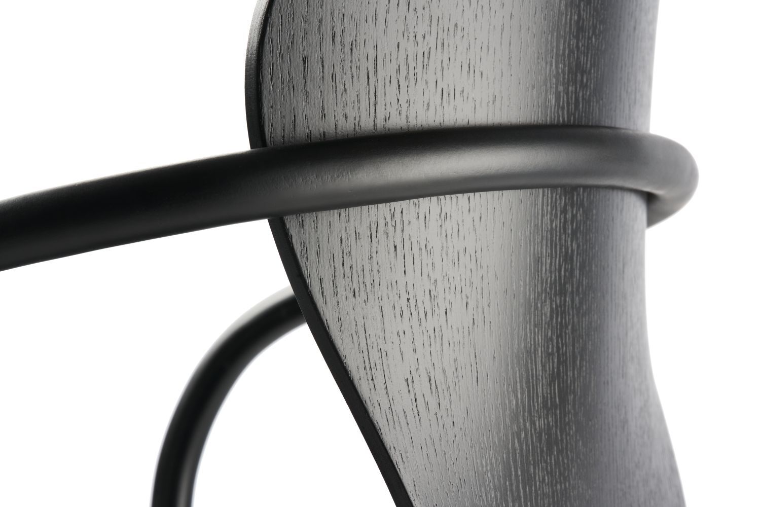Nahaufnahme eines ergonomischen Stuhlrückens aus Holz mit schwarzen Metallakzenten.