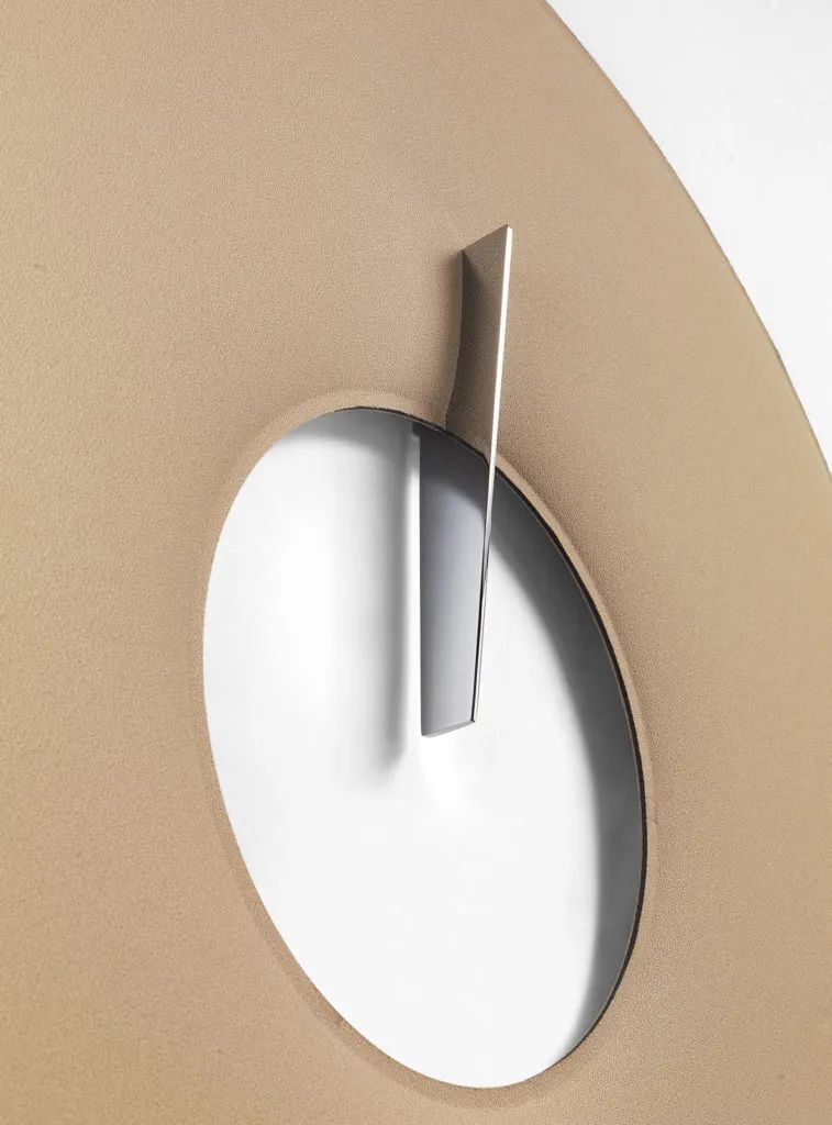 Nahaufnahme eines eleganten, modernen Uhrzeigers auf beigem Hintergrund, mit minimalistischer Ästhetik.