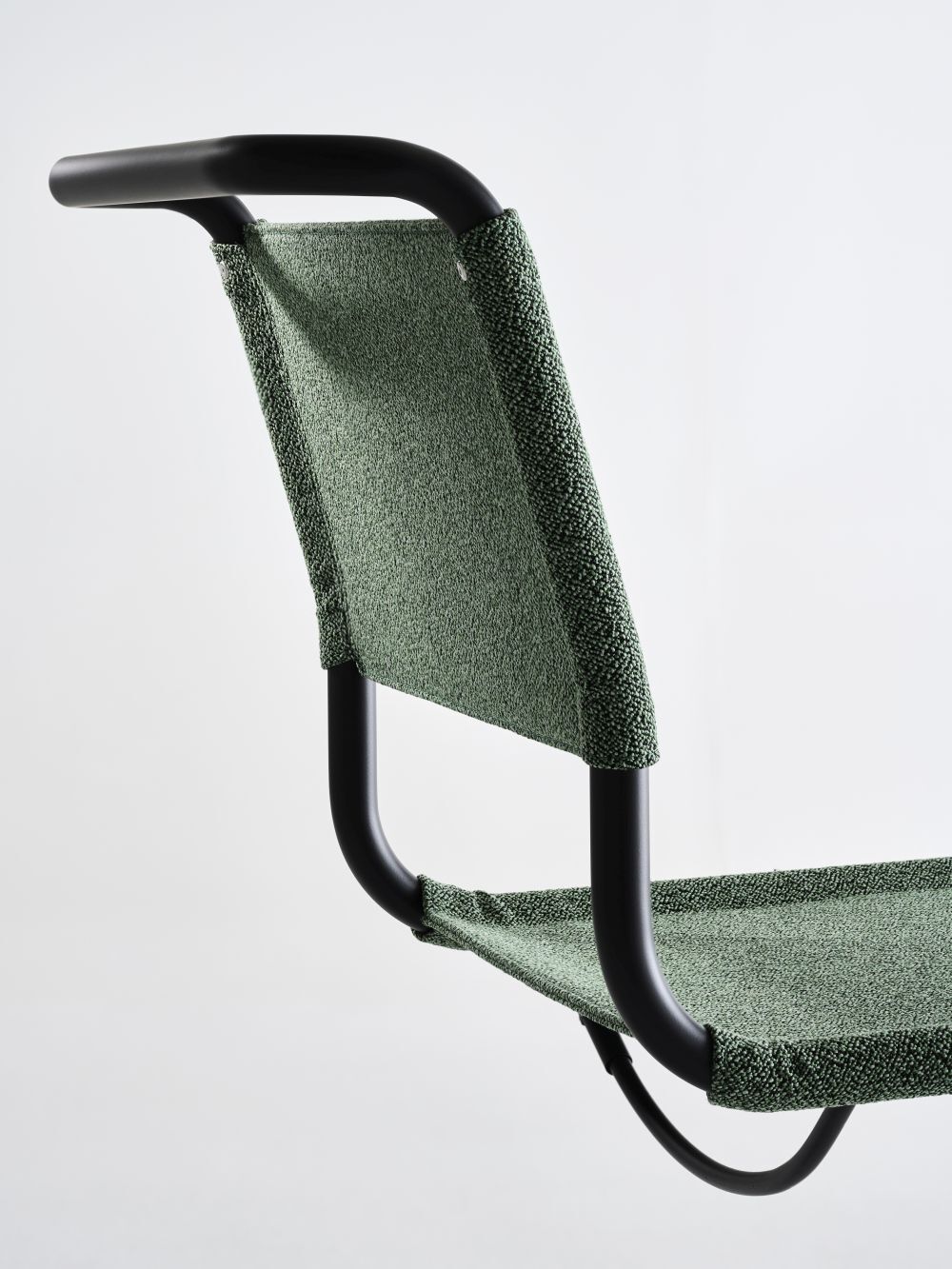 Rückenlehne eines grünen ergonomischen Bürostuhls mit schwarzem Rahmen, zeigt hochwertige Verarbeitung und Materialstärke.