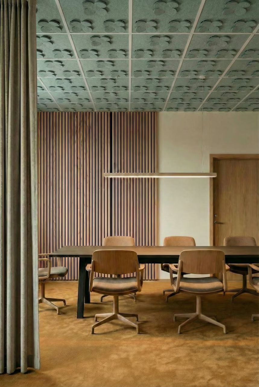 Modernes Büro mit ergonomischen Stühlen und stilvoller Holzverkleidung, ideal für gesundes Sitzen und Arbeiten.