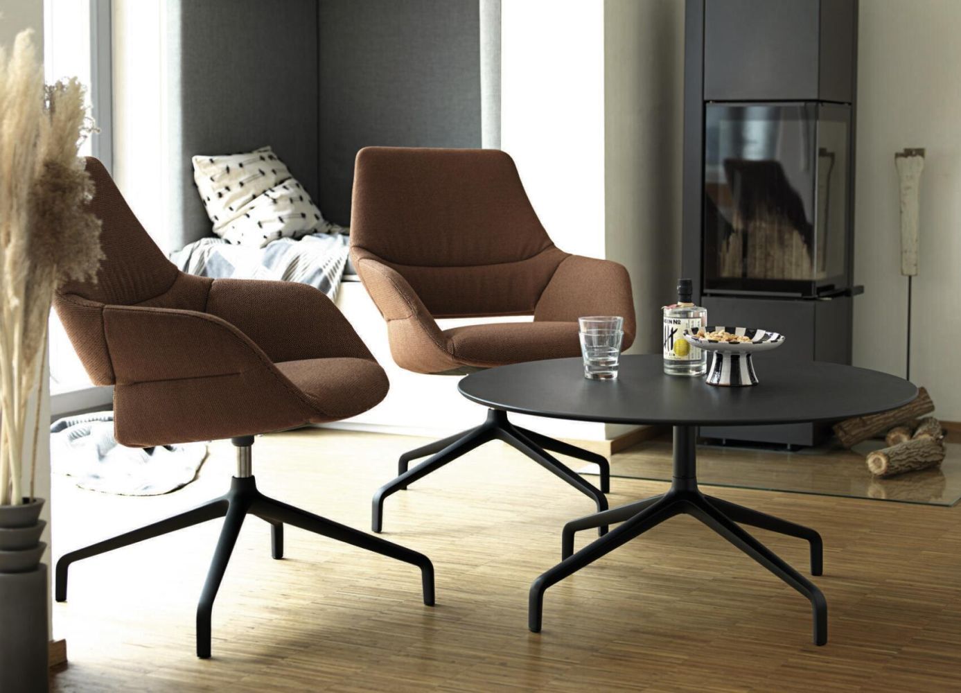 Zwei braune ergonomische Sessel mit schwarzem Tisch in modernem, stilvollem Wohnzimmer.