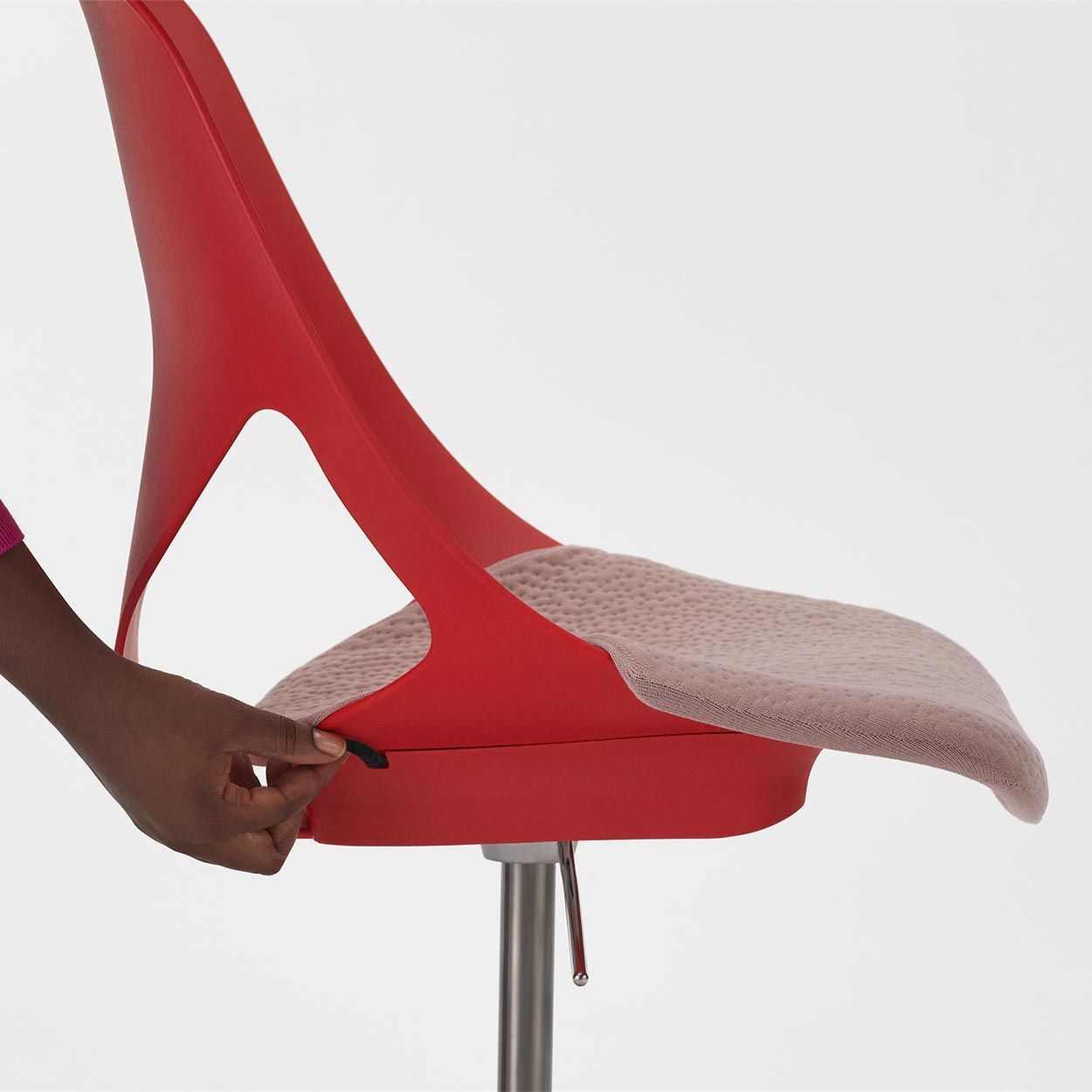 Nahaufnahme eines roten ergonomischen Stuhls mit verstellbarem Sitz, betont dynamisches Sitzen.