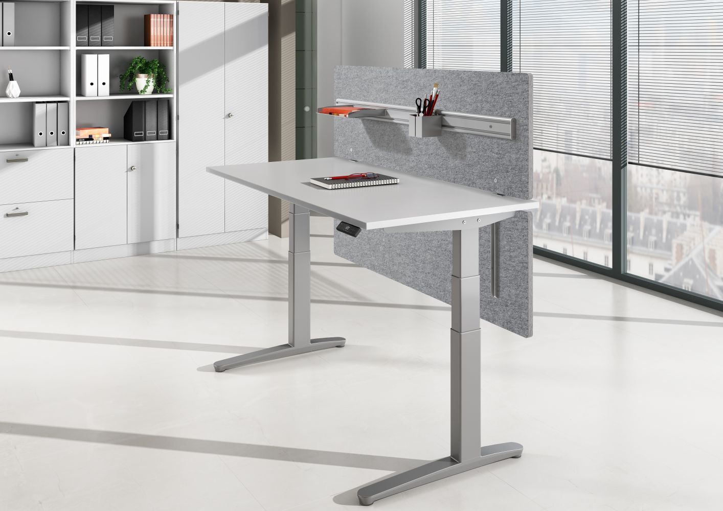 Höhenverstellbarer Schreibtisch mit grauer Trennwand und Bürobedarf, ideal für ergonomisches Arbeiten in modernen Büros.