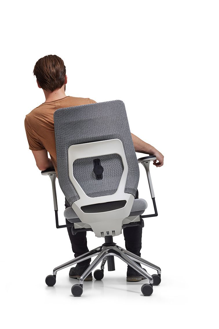 Person sitzt dynamisch in einem ergonomischen Bürostuhl mit Netzrückenlehne und beweglichem Sitz.