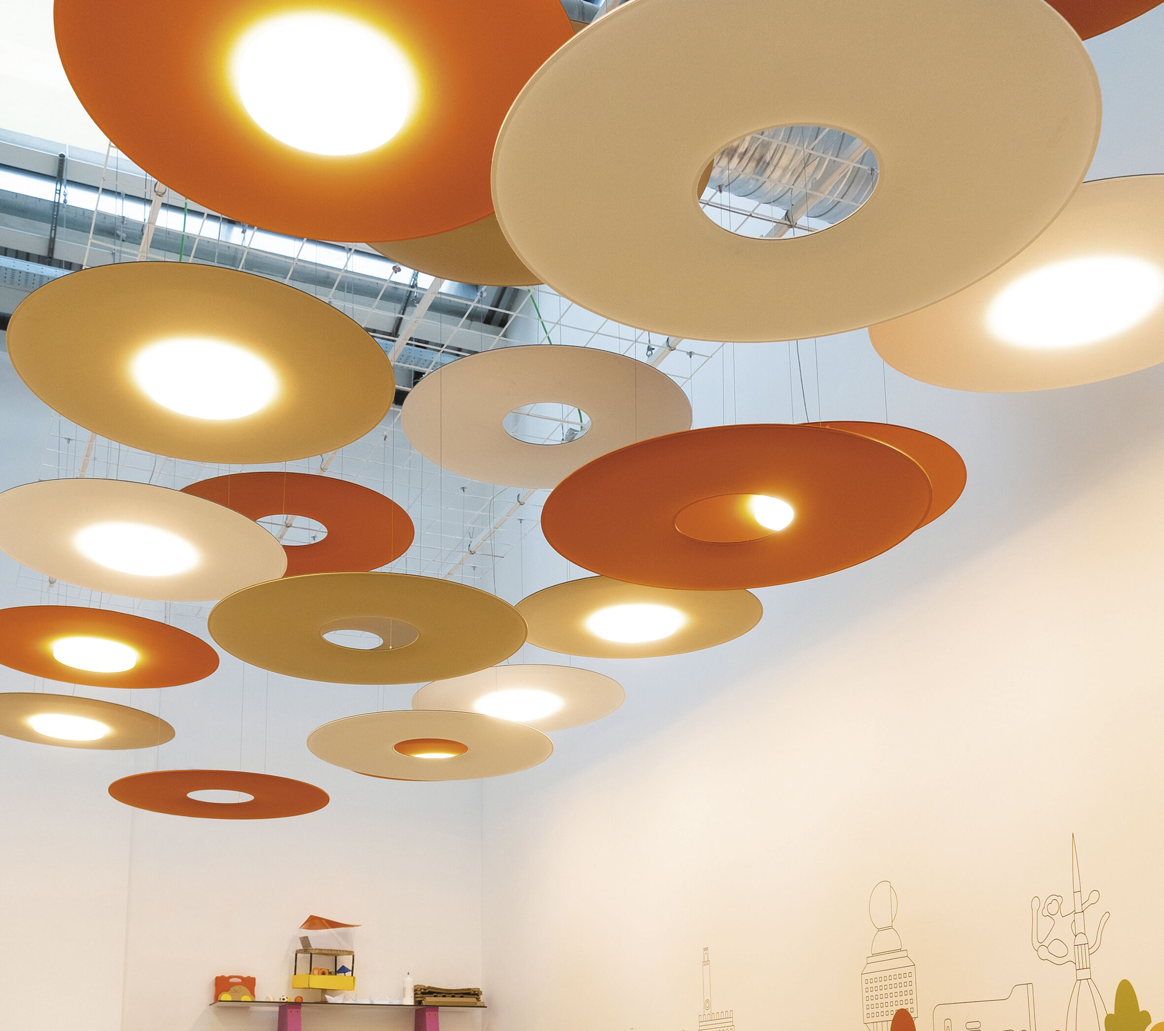 Runde, orange und beige Deckenleuchten in modernem Design, beleuchten einen weißen Raum stilvoll.