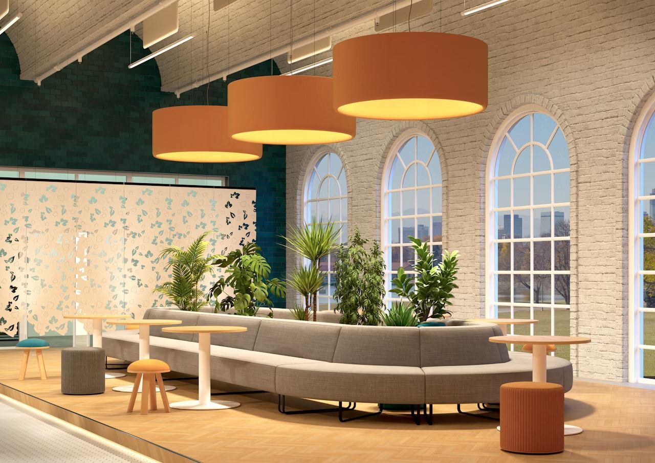 Moderne Lounge mit ergonomischen Sofas, Tischen und Pflanzen, beleuchtet von großen, warmen Deckenleuchten.