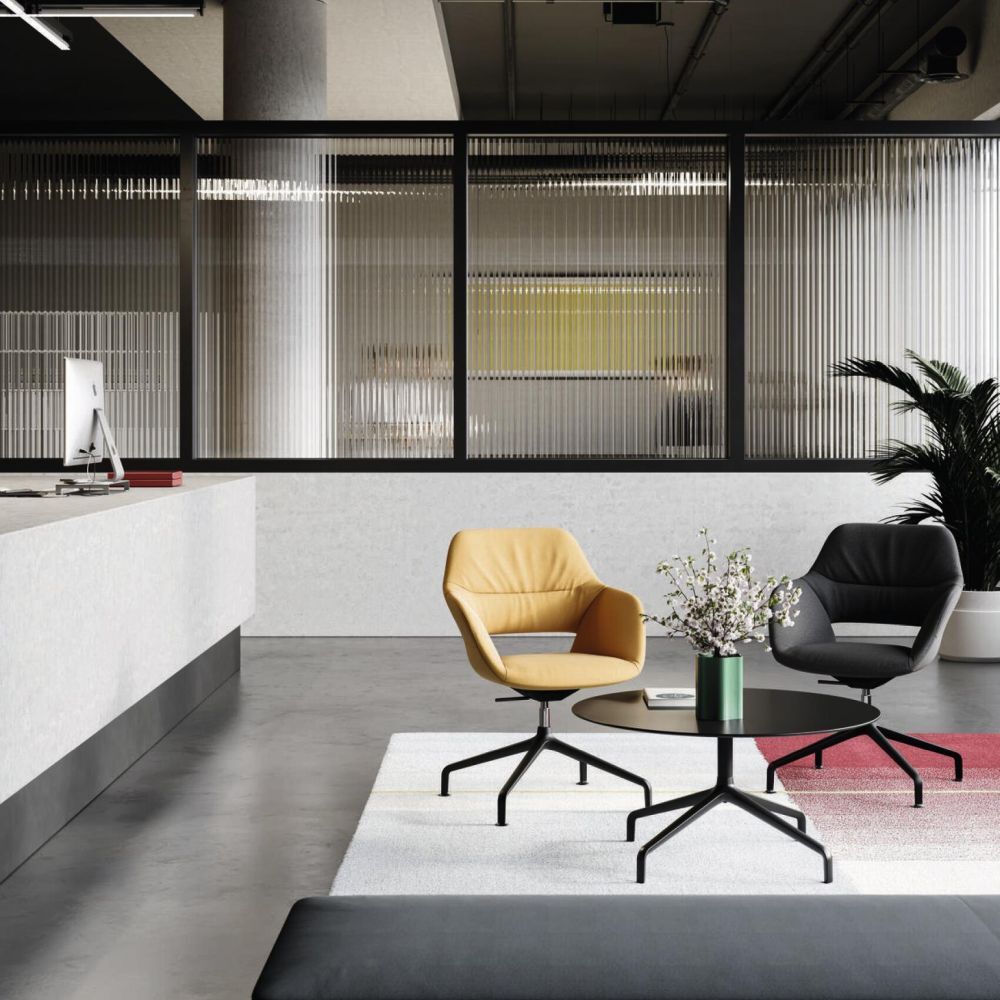 Moderne Büroeinrichtung mit gelbem und schwarzem ergonomischem Stuhl, Couchtisch und Vase auf hellem Teppich.