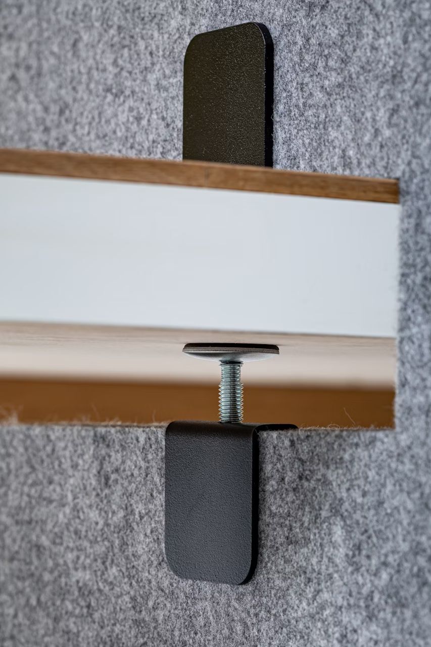 Nahaufnahme eines ergonomischen Stuhlmechanismus mit Schraube, montiert auf Filzstoff, betont Qualität und Funktionalität.