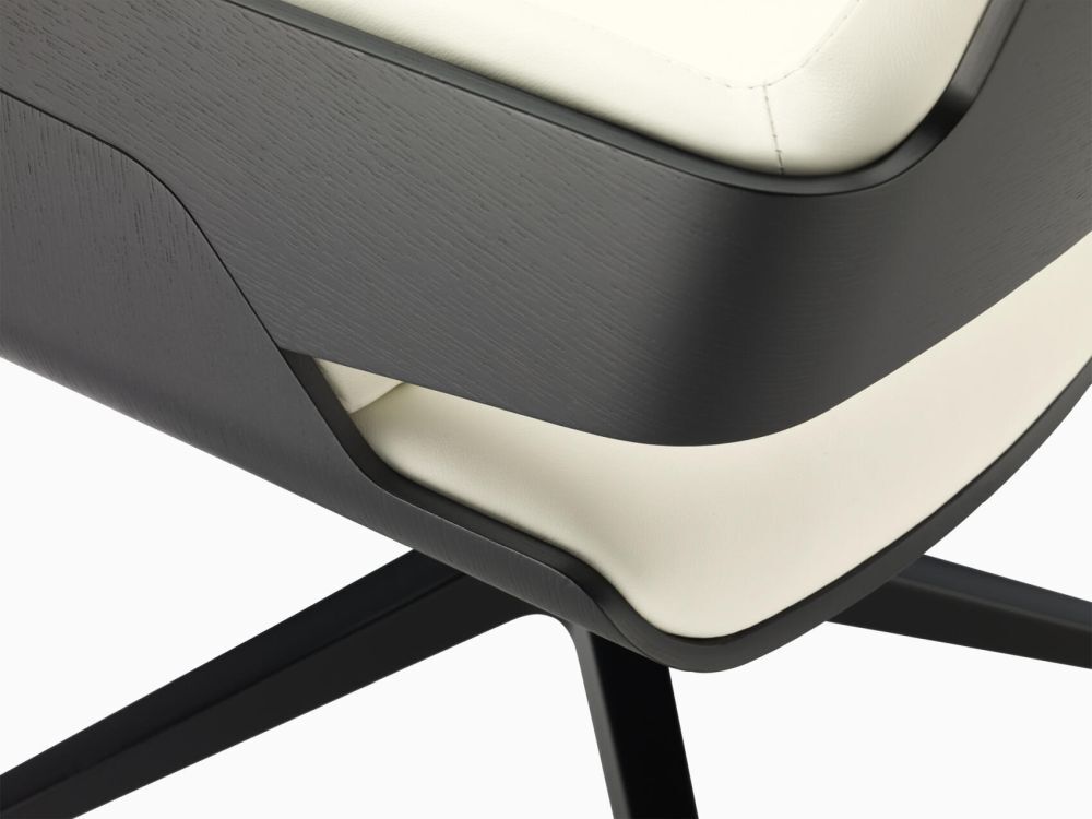 Nahaufnahme eines ergonomischen Bürostuhls mit schwarzem Gestell und heller Polsterung.