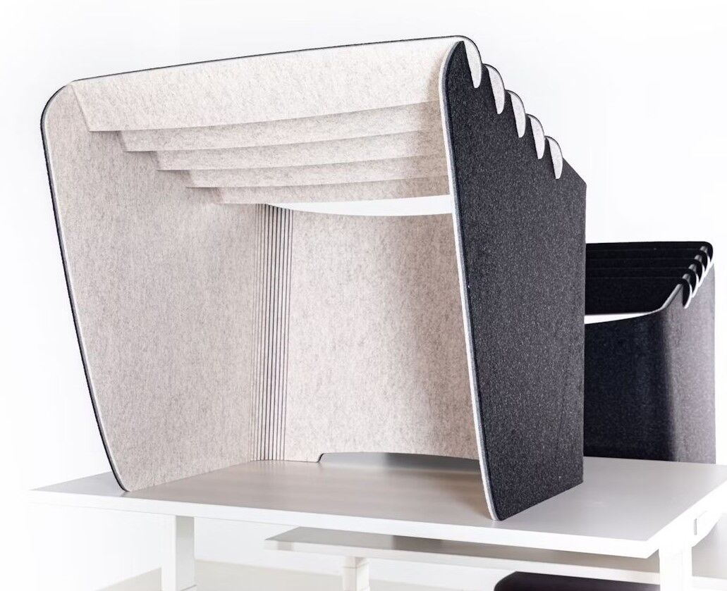 Moderner, ergonomischer Bürotrenner aus grauem Filz auf einem weißen Tisch, ideal für Privatsphäre im Büro.