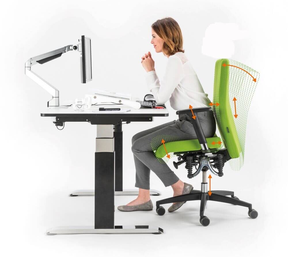 Frau sitzt auf ergonomischem Bürostuhl an verstellbarem Schreibtisch, betont dynamisches Sitzen und Flexibilität.