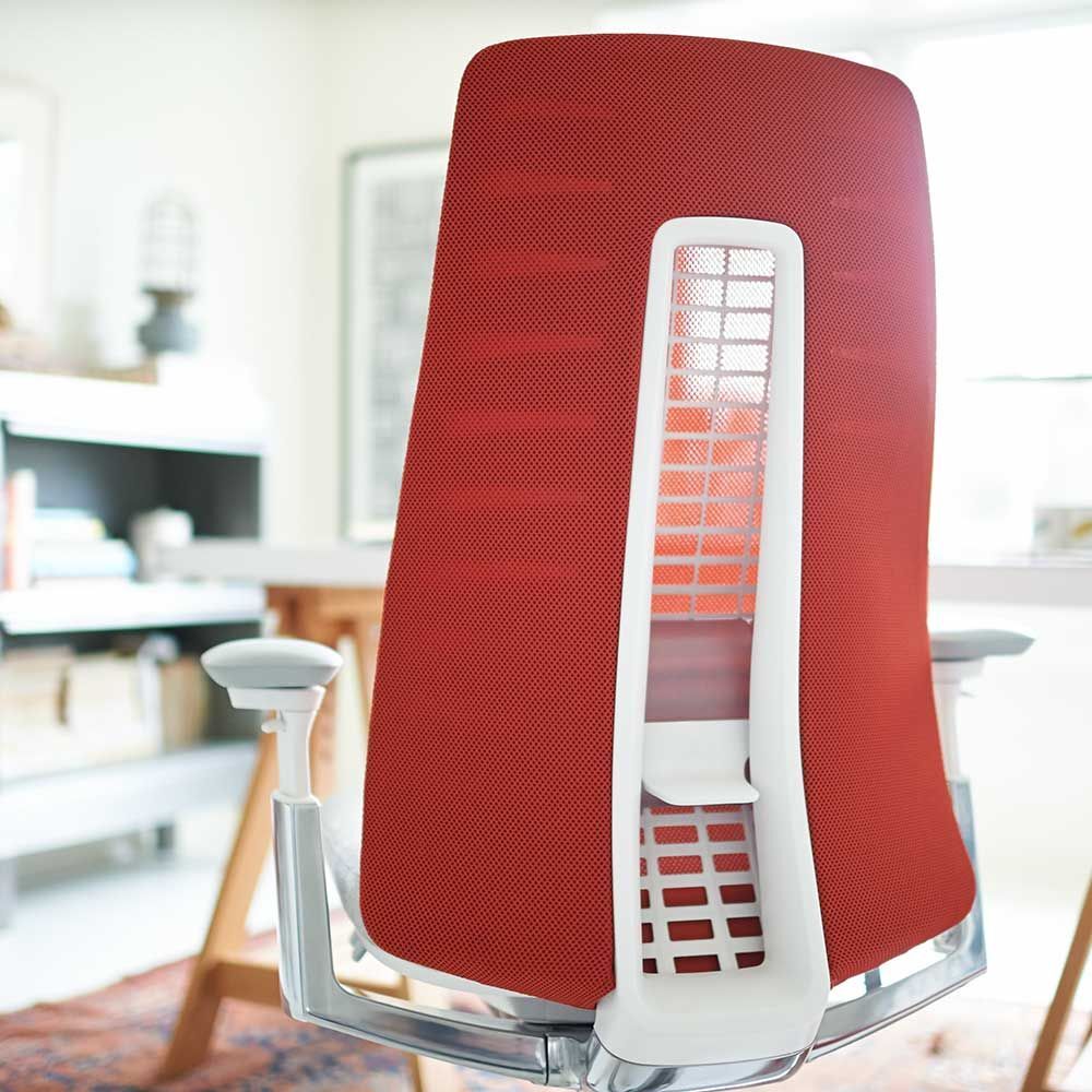 Ergonomischer Bürostuhl mit roter Netzrückenlehne und verstellbarer Unterstützung, geeignet für dynamisches Sitzen.