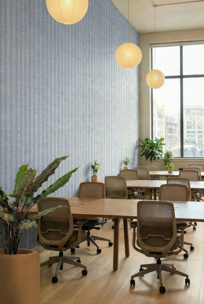 Moderne Büroumgebung mit ergonomischen Stühlen, großen Fenstern und Pflanzen für ein gesundes Arbeitsumfeld.