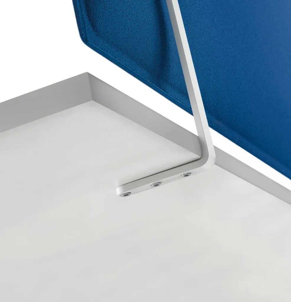 Detailansicht einer blauen Trennwand aus Stoff, montiert an einer Tischkante mit weißer Halterung.