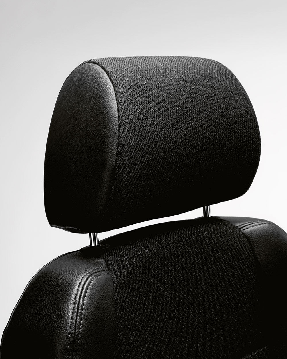 Nahaufnahme einer schwarzen ergonomischen Kopfstütze mit Polsterbezug, betont Komfort und Design.