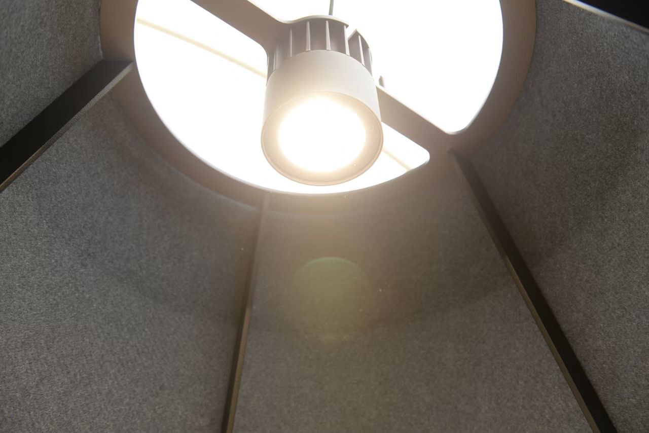 Helle LED-Leuchte in einem modernen, schallisolierten Raum mit grauen Wänden für Büroanwendungen.