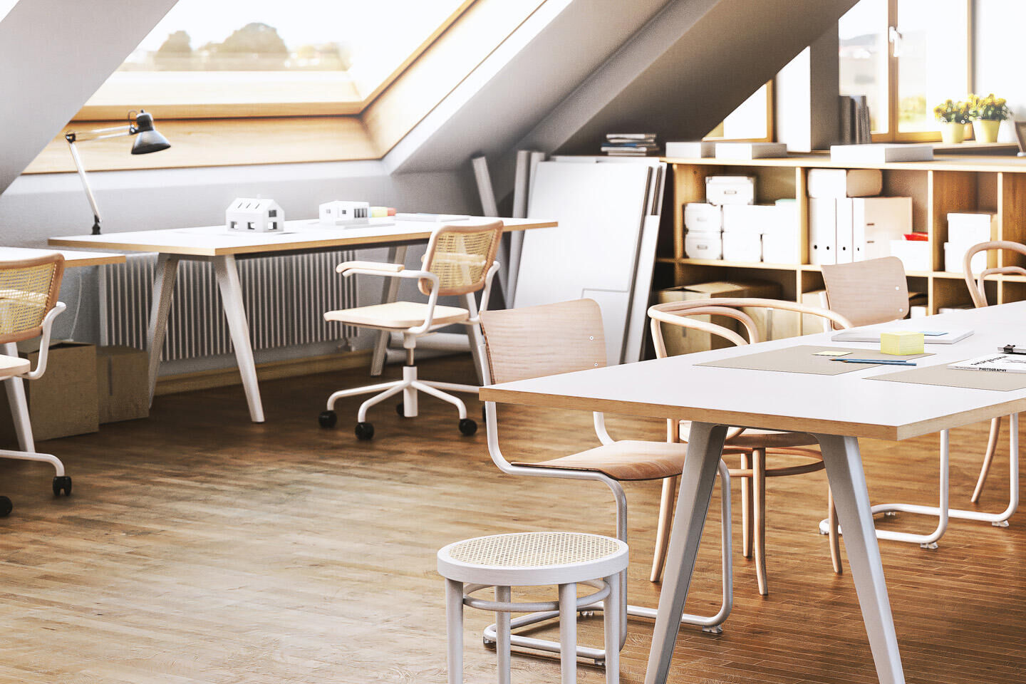 Moderner Dachboden-Büroraum mit ergonomischen Stühlen und Tischen, viel Tageslicht durch Dachfenster.