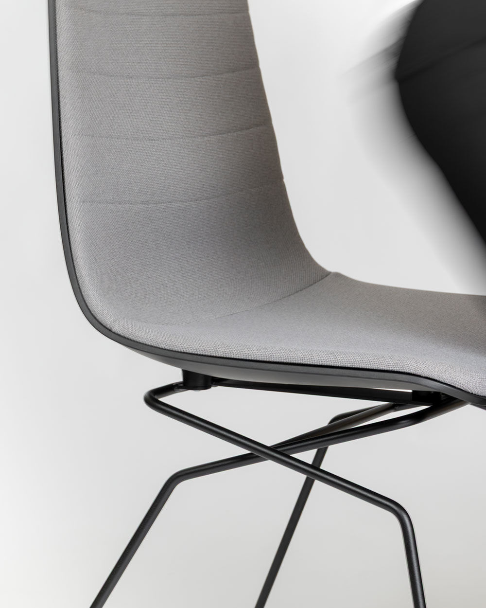 Grauer ergonomischer Stuhl mit modernem Metallgestell, geeignet für dynamisches Sitzen im Büro.