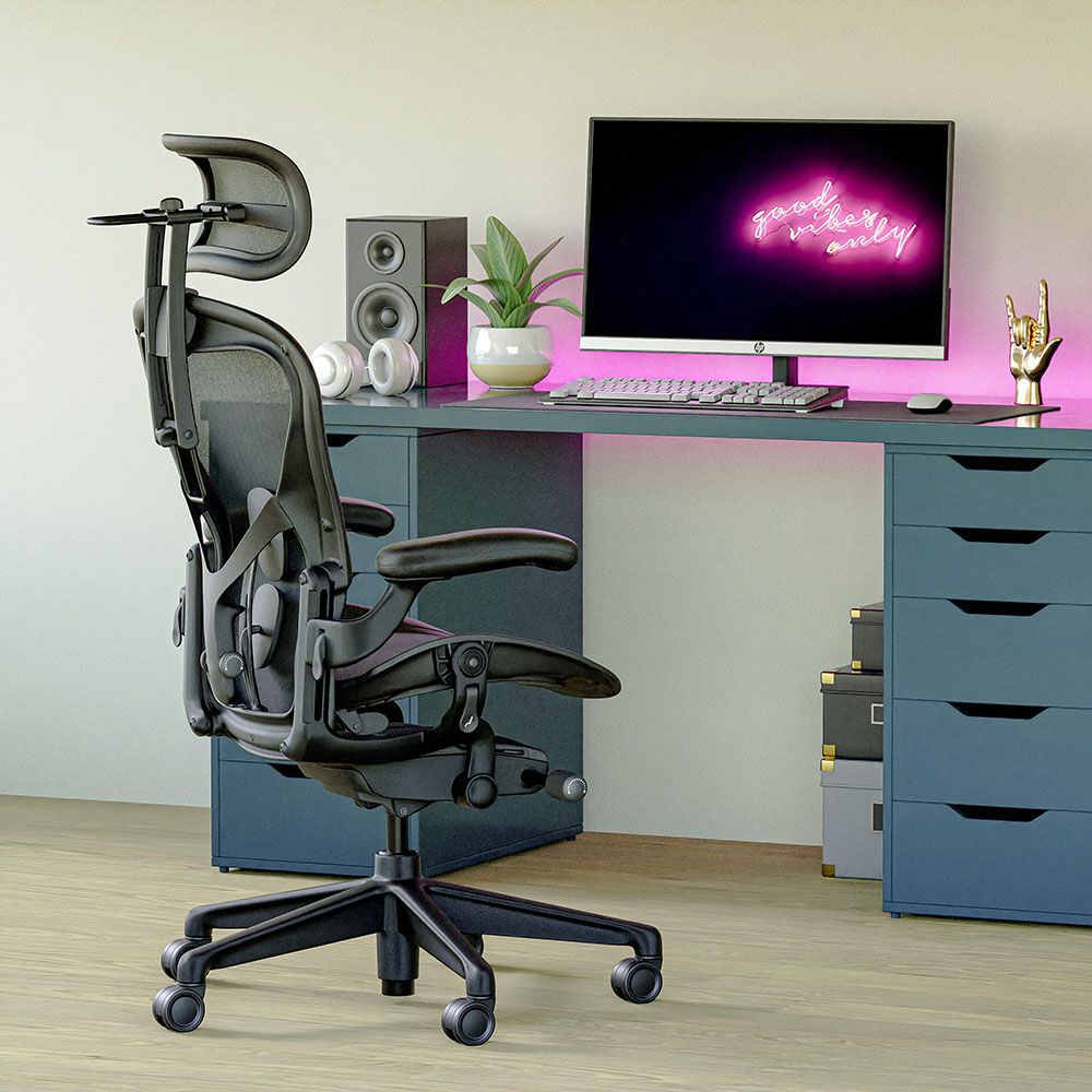 Ergonomischer Bürostuhl mit Kopfstütze vor altem Holzschreibtisch mit Monitor und Pflanzen.
