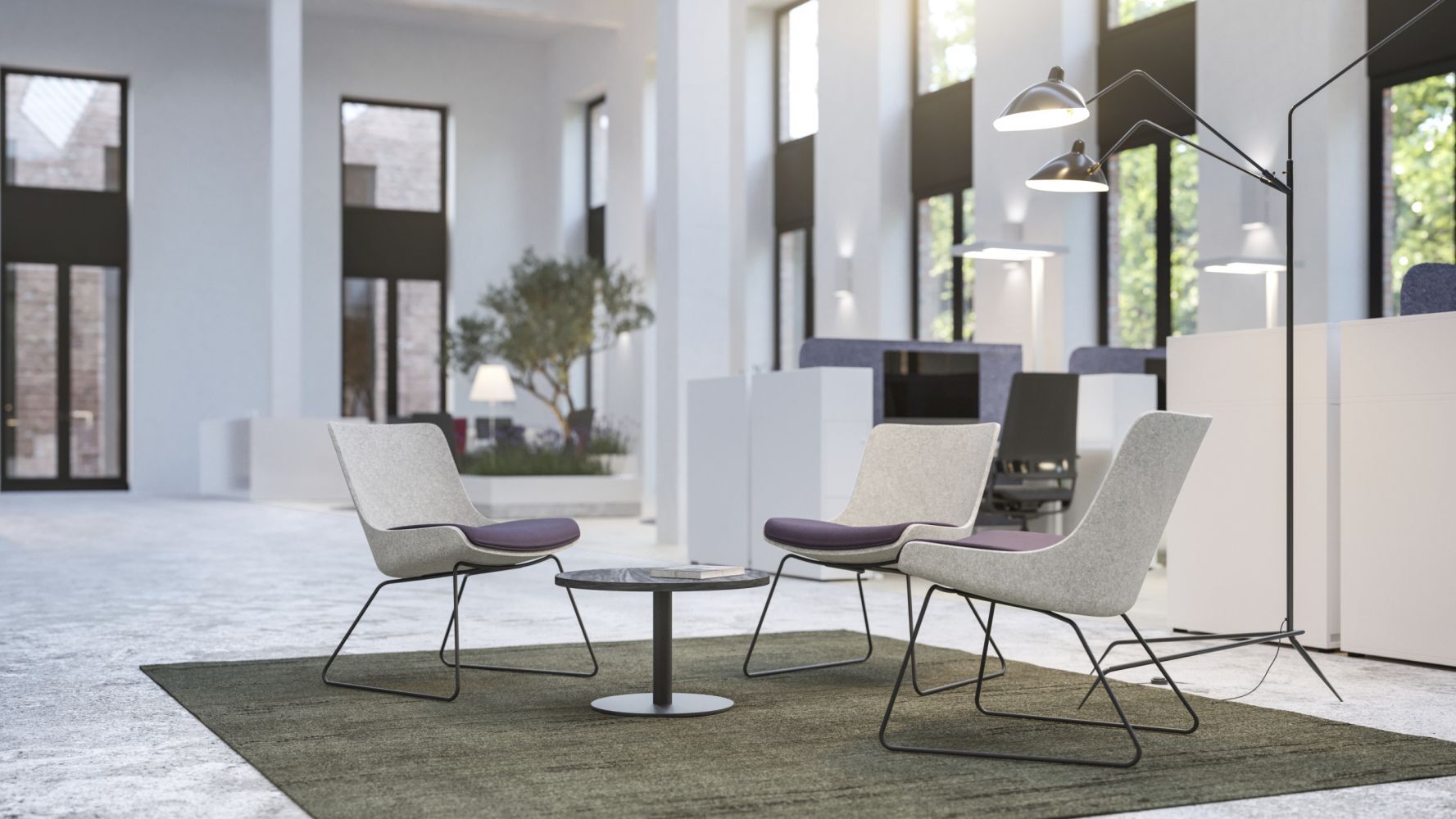 Moderner Lounge-Bereich mit zwei ergonomischen Sesseln und kleinem Tisch, umgeben von heller, offener Büroarchitektur.