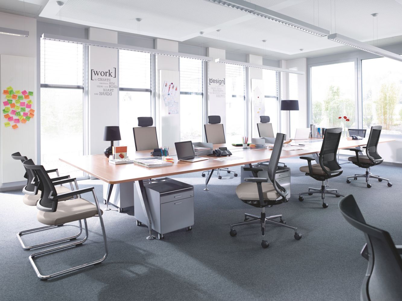 Helles Büro mit ergonomischen Schreibtischstühlen um einen großen Tisch, ideal für dynamisches Arbeiten.