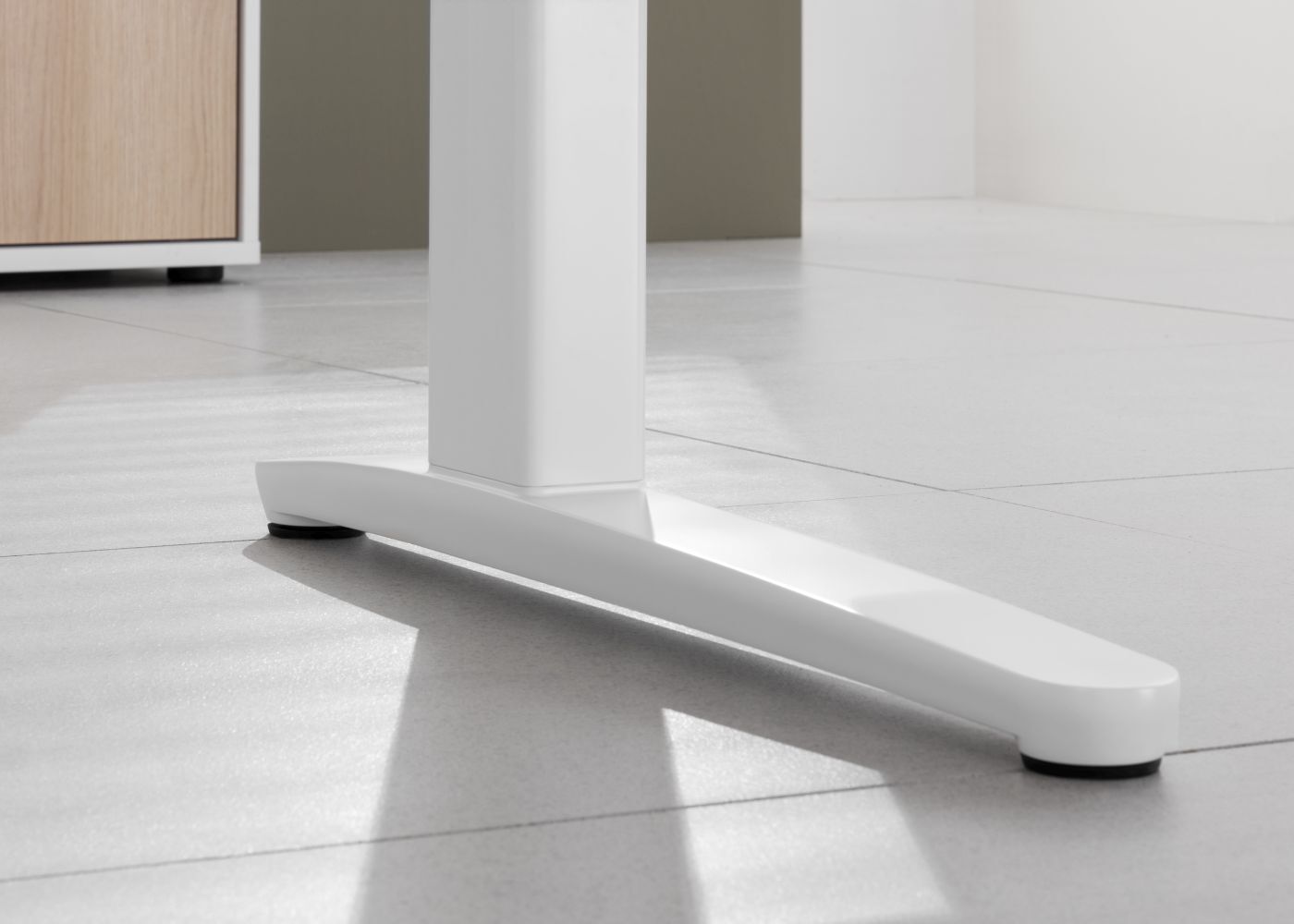 Nahaufnahme eines modernen weißen Tischgestells auf hellen Fliesen, zeigt minimalistisches Design und Stabilität.