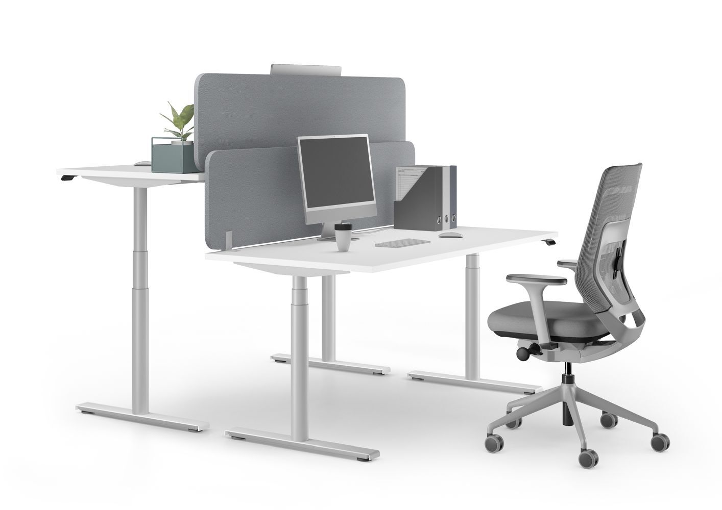 Ergonomischer Arbeitsplatz mit höhenverstellbarem Schreibtisch, grauem Bürostuhl und Monitor, fördert bewegtes Sitzen.