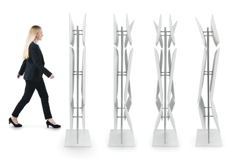 Frau im Anzug geht an vier stilvollen, weißen Raumteilern vorbei.